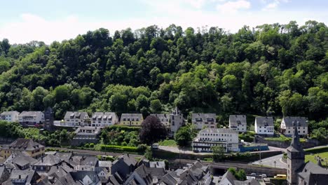 aerial flying drone shot of the rhine river valley and old architecture - including medieval castles, old buildings, and natural forested alpine hills