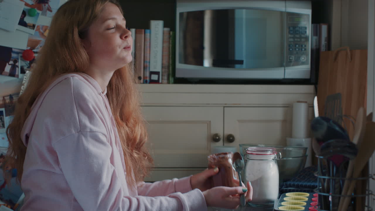 ⁇ 청한 십대 소녀가 부 ⁇ 에 있는 항아리에서 초콜릿을 먹고 맛있는 맛을 즐기고  ⁇ 청한 십대 소녀가 집에서 건강하지 않은 간식을 즐기고 있습니다.