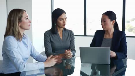 diverse businesswomen collaborating on laptop in modern office meeting