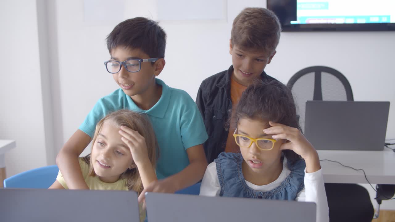 des élèves méchants concentrés assis et debout au bureau