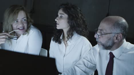 colegas discutiendo el trabajo en la oficina oscura