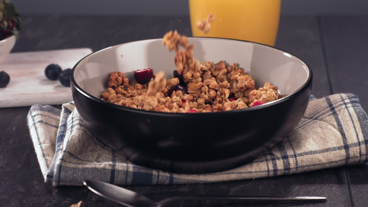 desayuno saludable en cámara súper lenta, granola de cereales cayendo en un cuenco en una mesa. filmado con cámara de alta velocidad a 420 fps