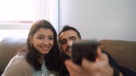 pareja amorosa con vino tomando una selfie en casa