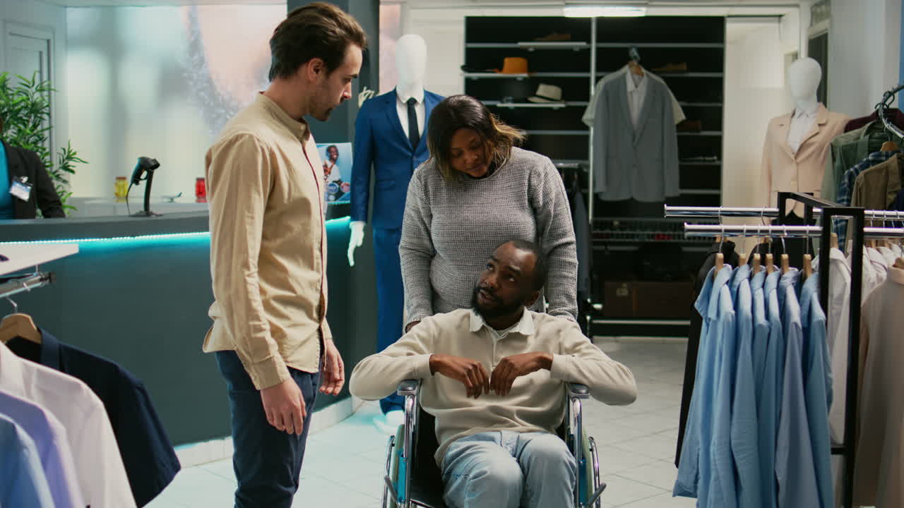 People shopping in a clothing store with assistance for a person in a wheelchair