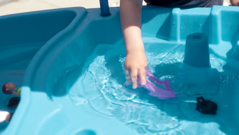 Un-Niño-Jugando-Con-Un-Barco-De-Juguete