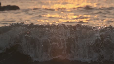 close up of crashing wave at sunset slow motion