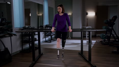 woman with leg prosthesis using parallel bars for rehabilitation