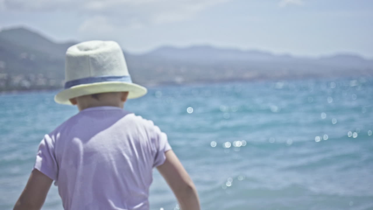 3살 된 아이는 칼라마타 해변, 그리스 슬로우 모션에서 바다와 파도를 즐깁니다.