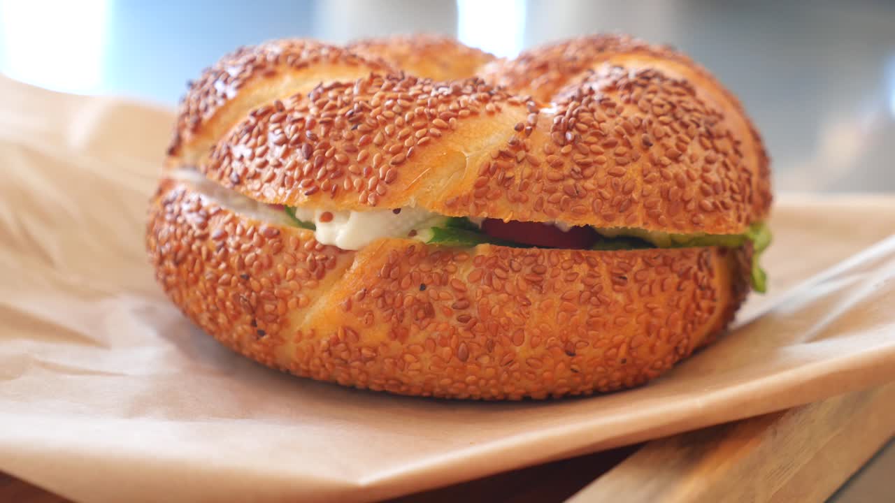 delicioso sándwich de bagel de sésamo con queso cremoso y verduras