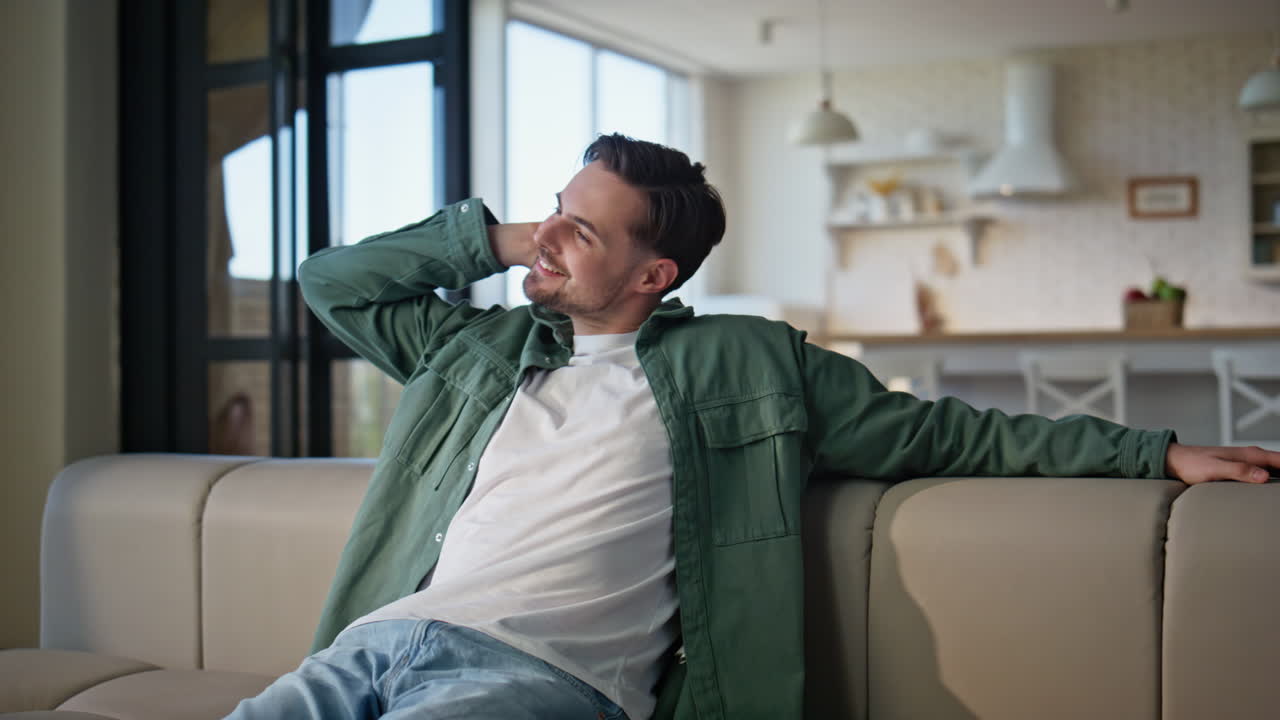 Casual guy falling on couch feeling relaxed home closeup. Carefree man resting