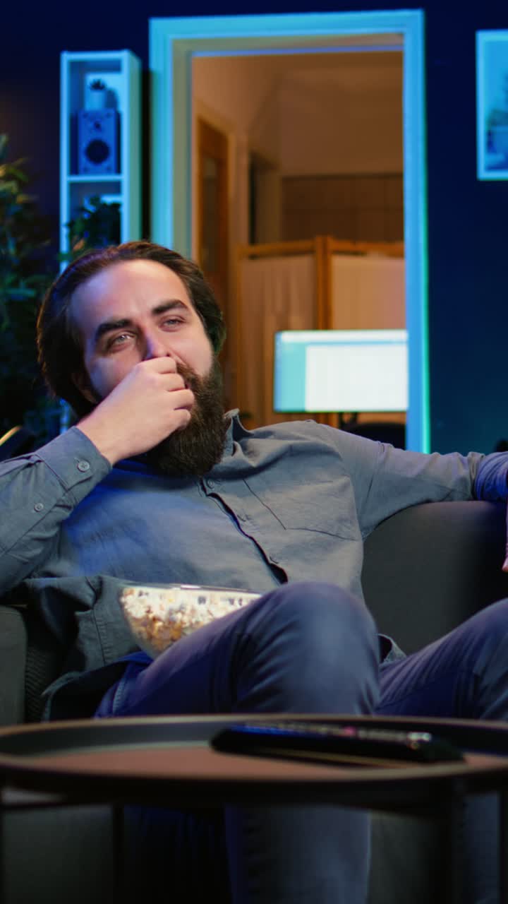 Vertical video Joyous homeowner using TV to watch comedy films on streaming services