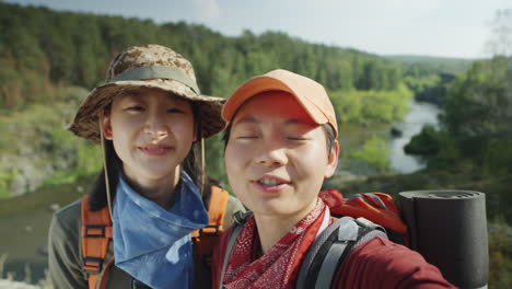 asian female tourists video calling on hike