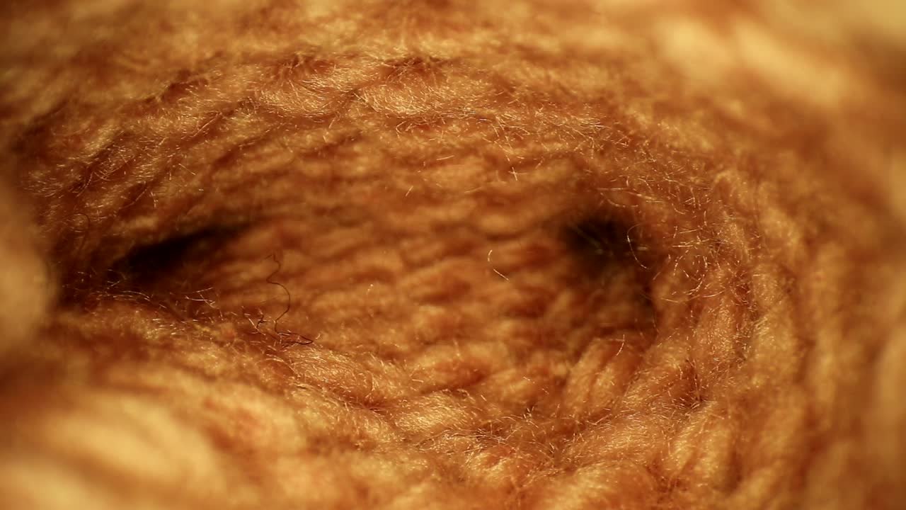 많은 섬유가 보이는 수제 분홍색 양말을 꺼냅니다.