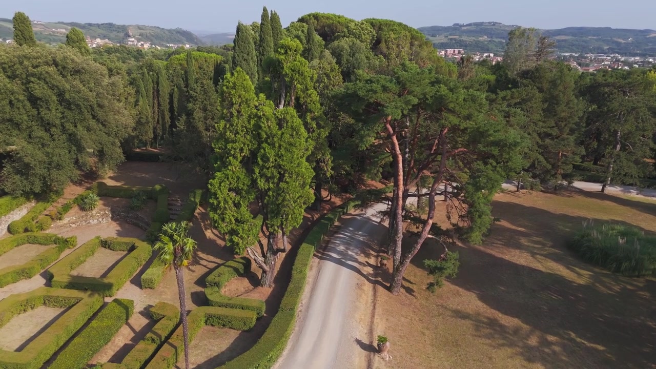 Vista aerea di un viale alberato e giardini formali accanto a una tenuta con villa storica
