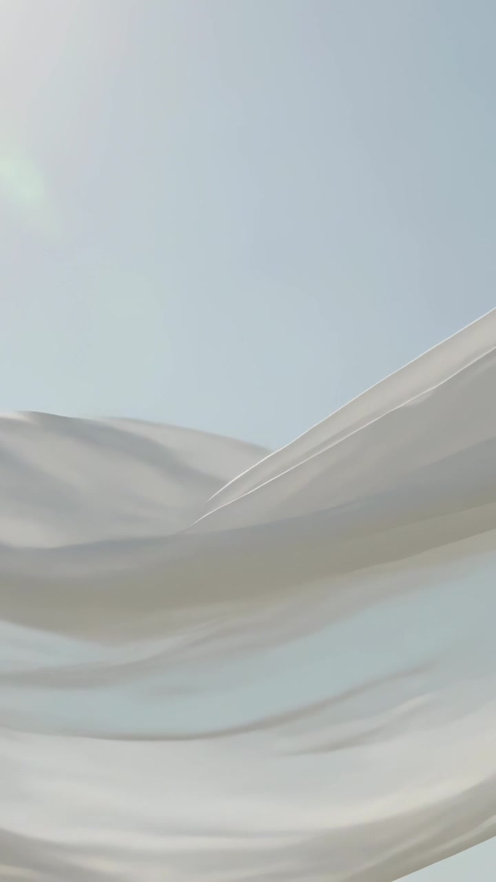 Video verticale: Telo bianco trasparente che ondeggia nel cielo azzurro pallido, rivelando il sole nella brezza.