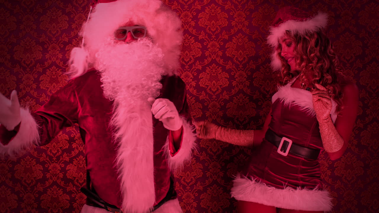 산타클로스와 크리스마스 의상을 입은 여성 크리스마스 디스코 촬영을 위해 춤을 춘다