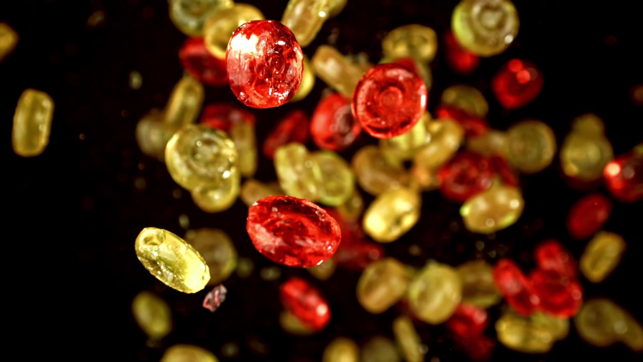Sweet Red and Yellow Hard Candies Floating in Slow Motion