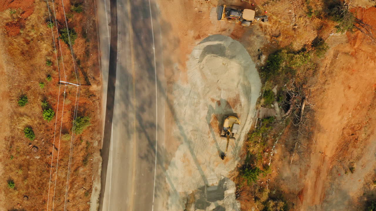 vista superior de una máquina de construcción al lado de una carretera de autopista