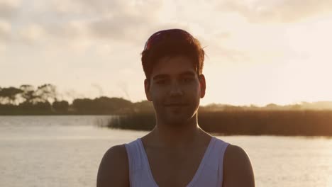 mixed race rower standing on jetty and looking at camera