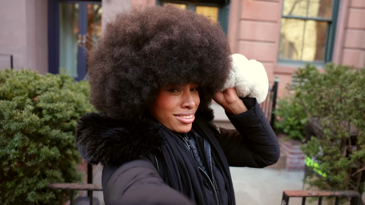 Donna con afro e cappotto invernale