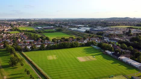 aerial shot flying over a city sports ground and recreational park in summer