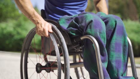 un hombre con discapacidad física conduce su silla de ruedas en cámara lenta.