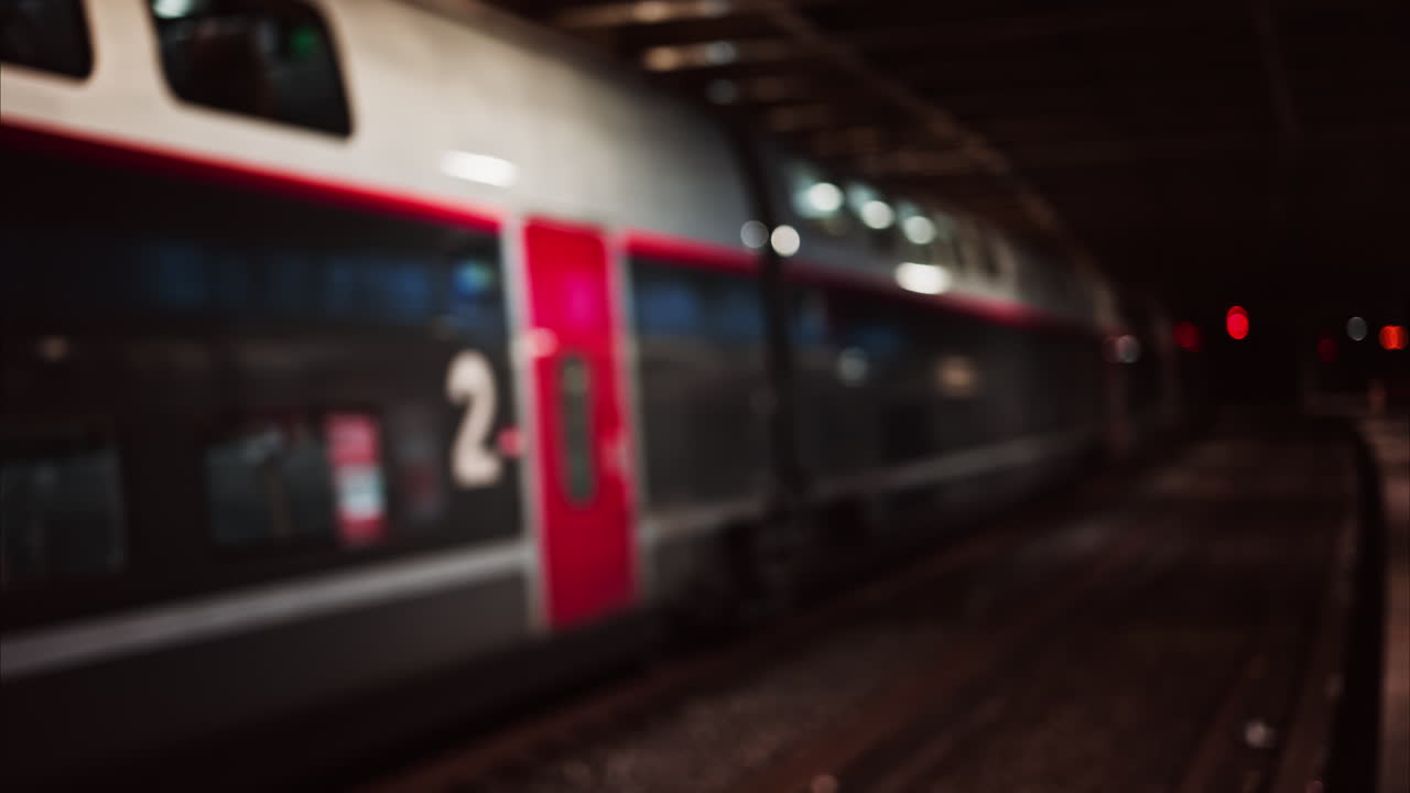 Blurred view of people and trains moving through the Cannes train station in the evening