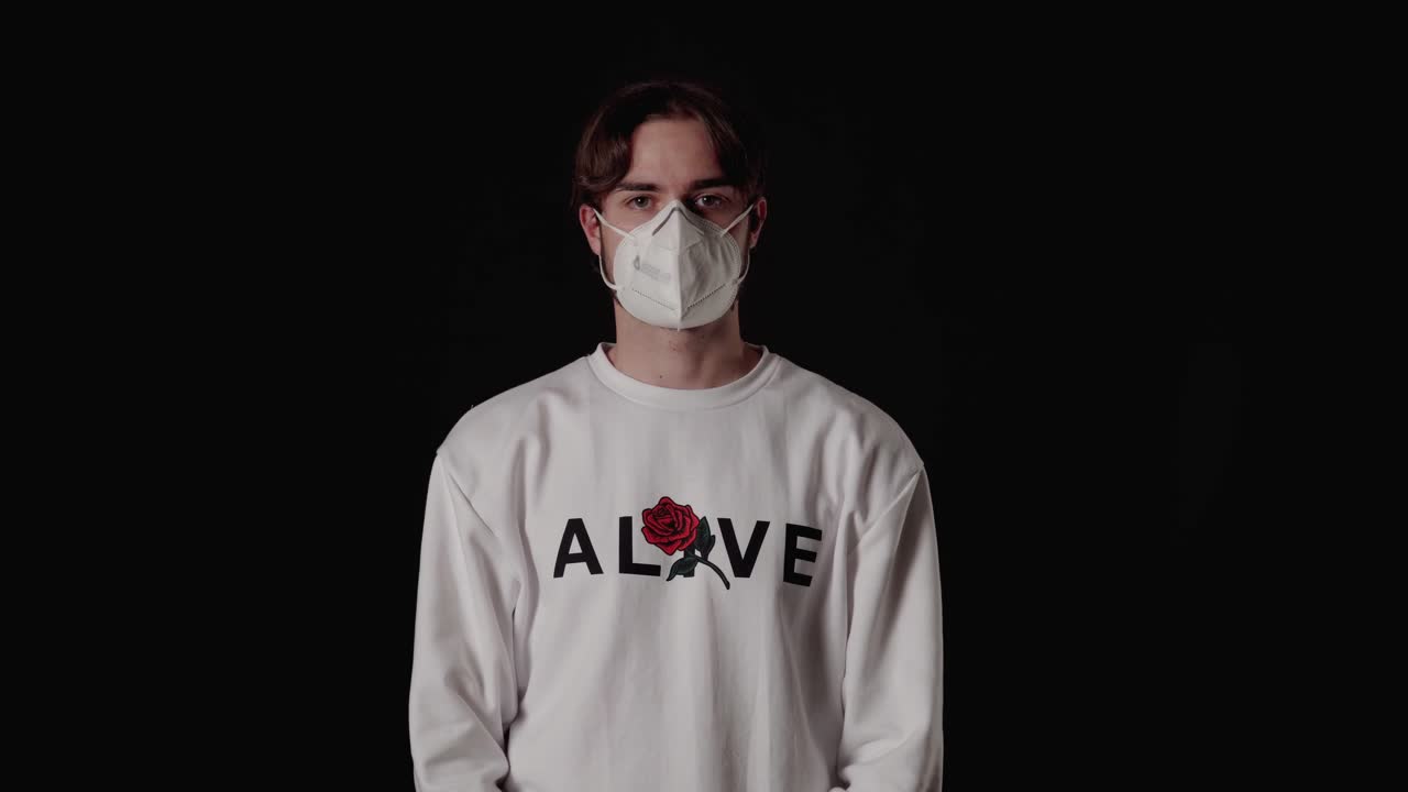 joven de moda poniéndose mascarilla, protección covid-19, fondo ancho y negro