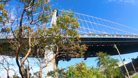 walking along the east river under the manhattan bridge on a sunny fall day