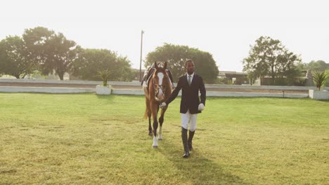 hombre afroamericano caminando con su caballo de doma