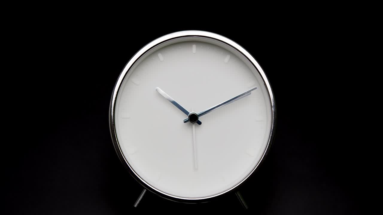 reloj de alarma plateado aislado sobre fondo negro.