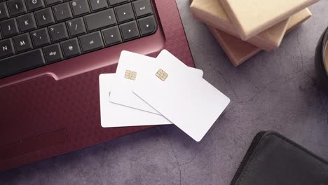 laptop with credit cards, coffee cup, and gift boxes on a desk