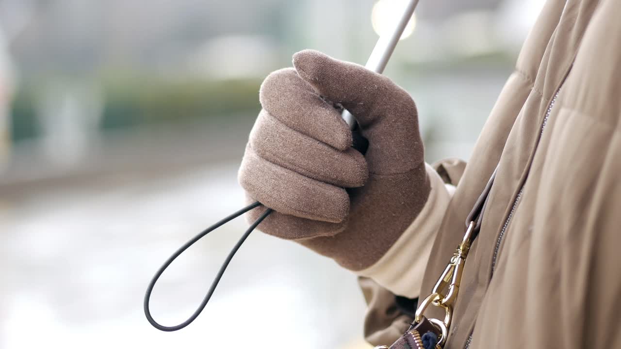 겨울 장갑으로 우산을 들고 있는 사람