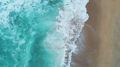 beautiful aerial ocean foaming splashing on sand beach. stormy sea water rolling