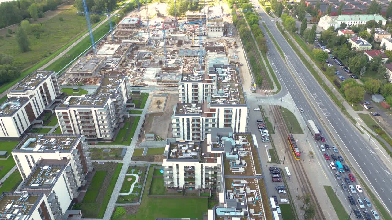 vista aérea de pájaro de un sitio de construcción construyendo grúas mirando hacia abajo área de maquinaria industrial alrededor de apartamentos urbanos residenciales