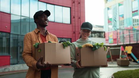 Couriers-holding-boxes-outdoors