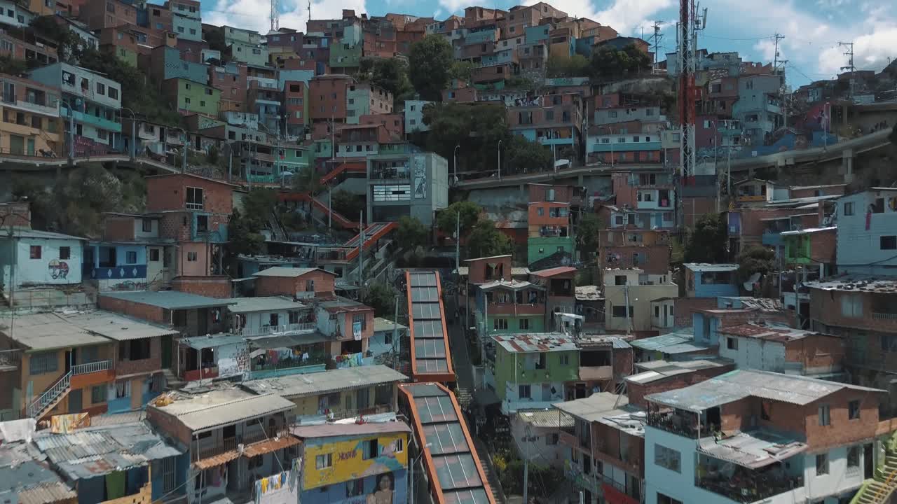 drone aéreo sobrevolando comuna 13 barrios marginales en medellín, colombia - escaleras mecánicas y casas en zona turística