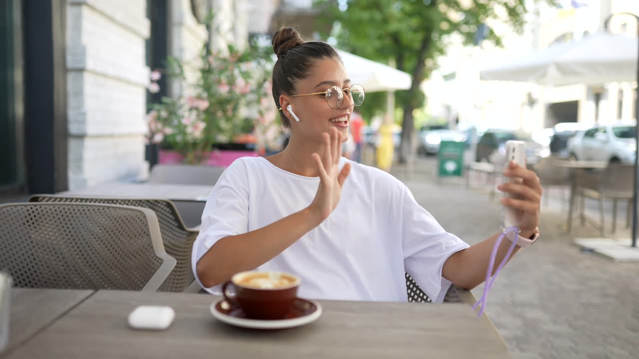 mujer joven en llamada de video en un café al aire libre