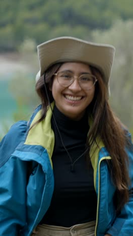 smiling young woman in a hat and jacket outdoors