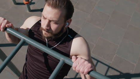 man doing pull ups on a outdoor gym