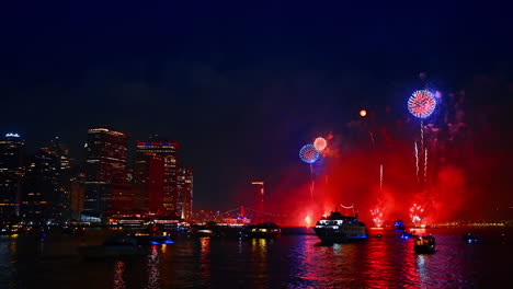 dark waterscape of the east river illuminated by the flashes of striking fireworks. stunning celebration show in new york, usa