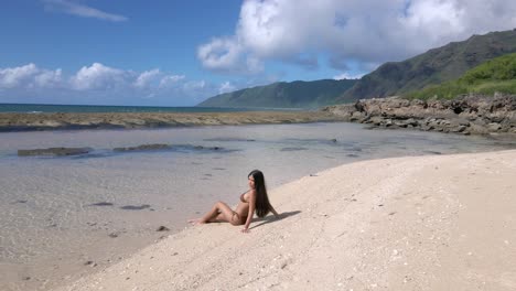 the beach becomes a haven for relaxation as a sun-kissed beauty with long black hair flaunts her brown bikini