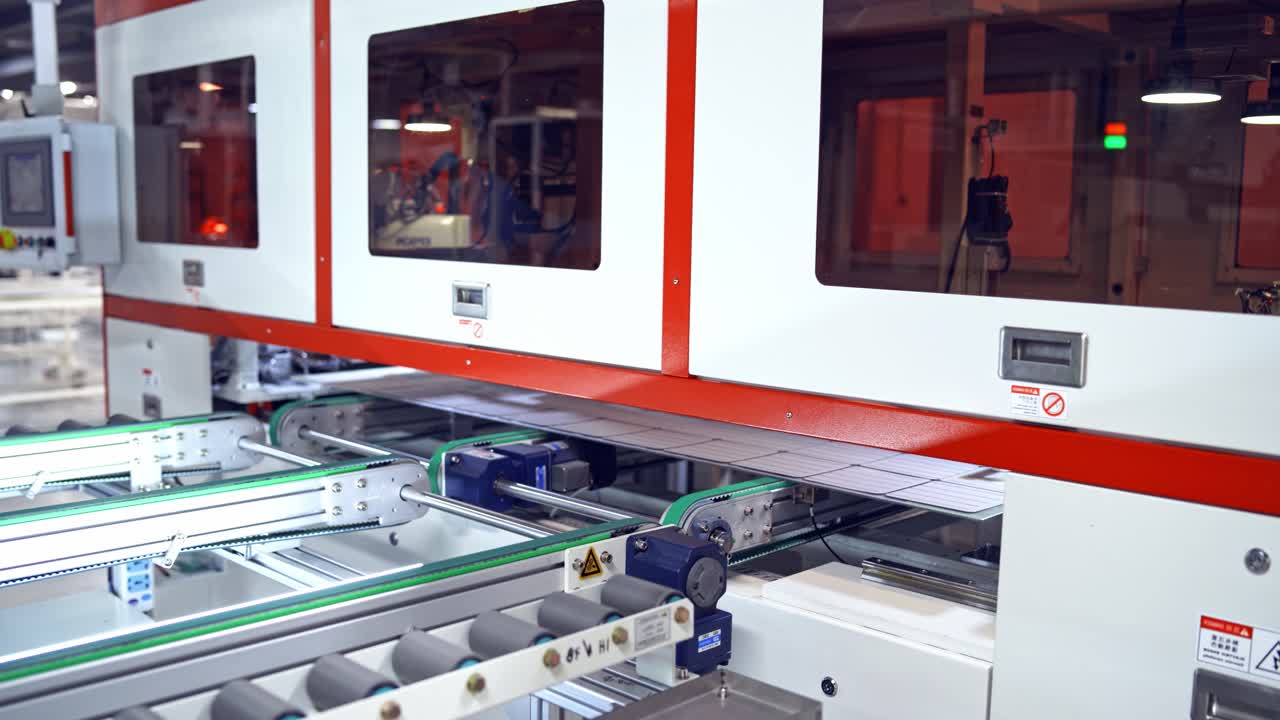 Robotic manufacturing indoors. Worker controls the process of automated equipment. Industrial background and engineer in blue uniform in a modern factory.