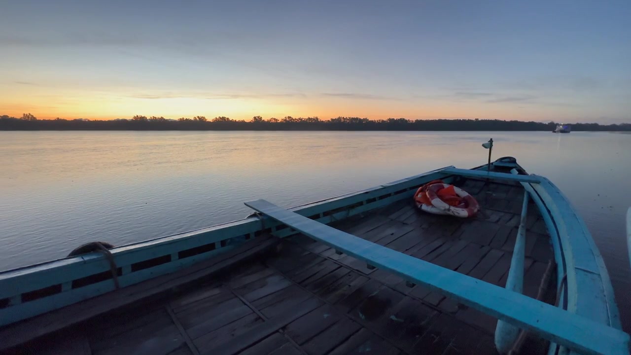 Lever de soleil dans le parc national des Sundarbans, bateau en bois au premier plan. Bangladesh.