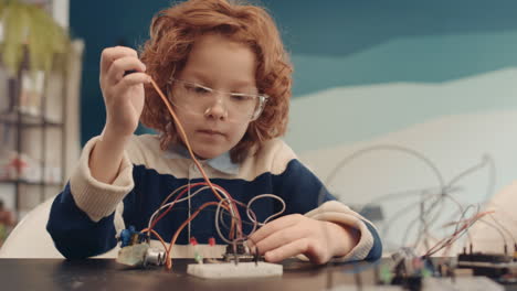 young boy focused on an electronics project