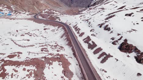 vehículos circulando en el paso internacional los libertadores con montañas nevadas en invierno en portillo, chile