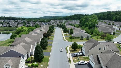 aerial tracking shot of white sedan in modern usa neighborhood