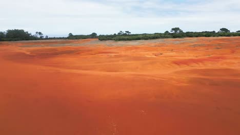 bright red-orange soil landscape under clear skies, captured on santa maria island