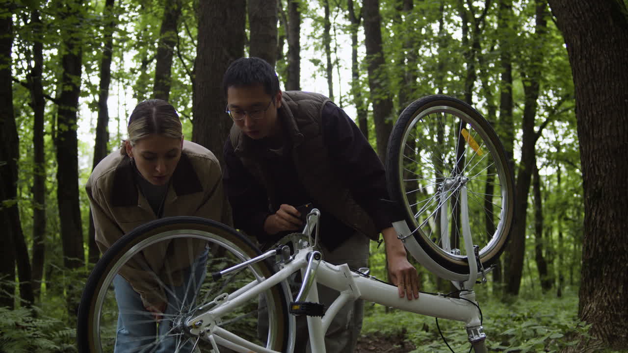 People repairing a bicycle in the forest