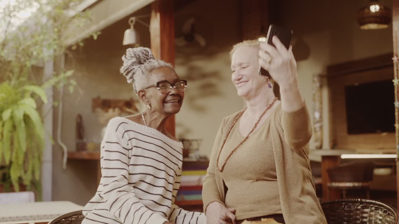 Two elderly women smiling and taking a selfie together